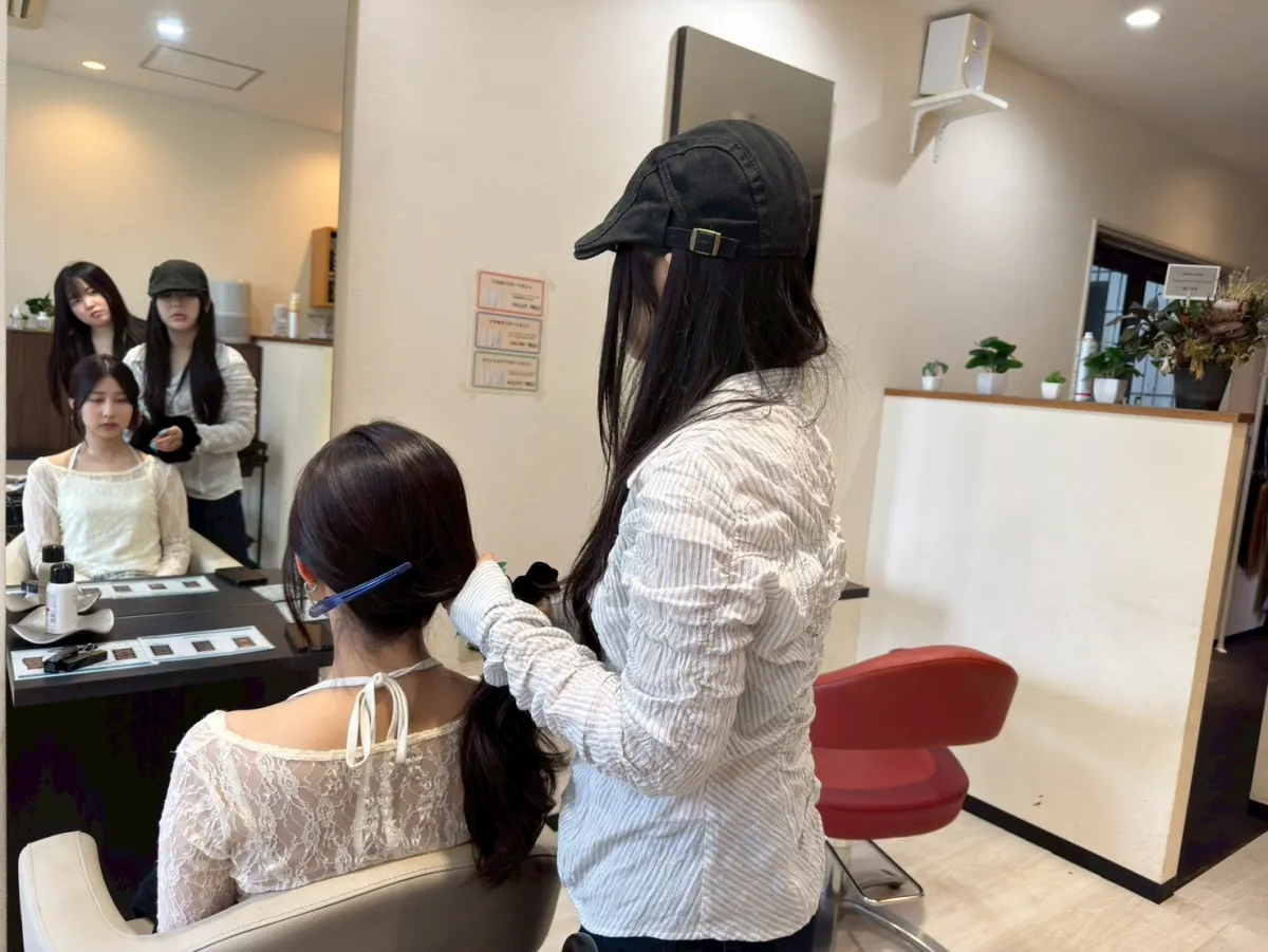 モデルのヘアスタイルを整えるスタッフ