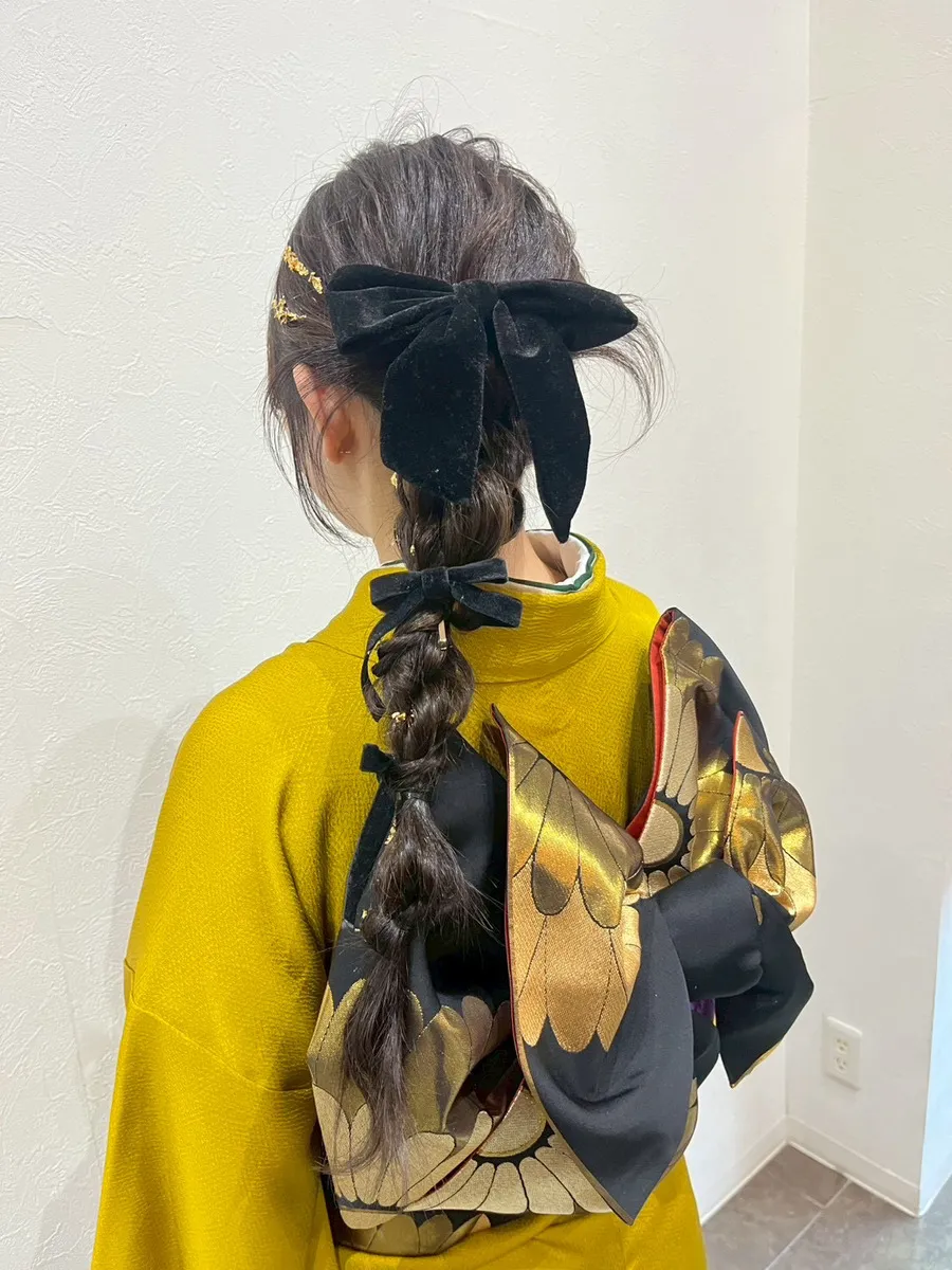 振袖の着付けとヘアセットの後ろ姿。黄色の振袖に黒と金の帯