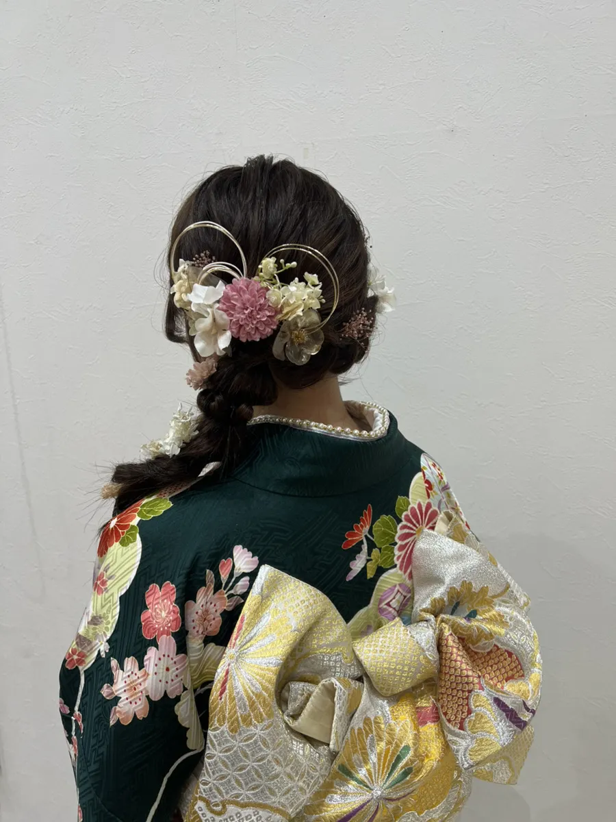 振袖の着付けとヘアセットの後ろ姿。深緑の花柄の振袖に金の帯