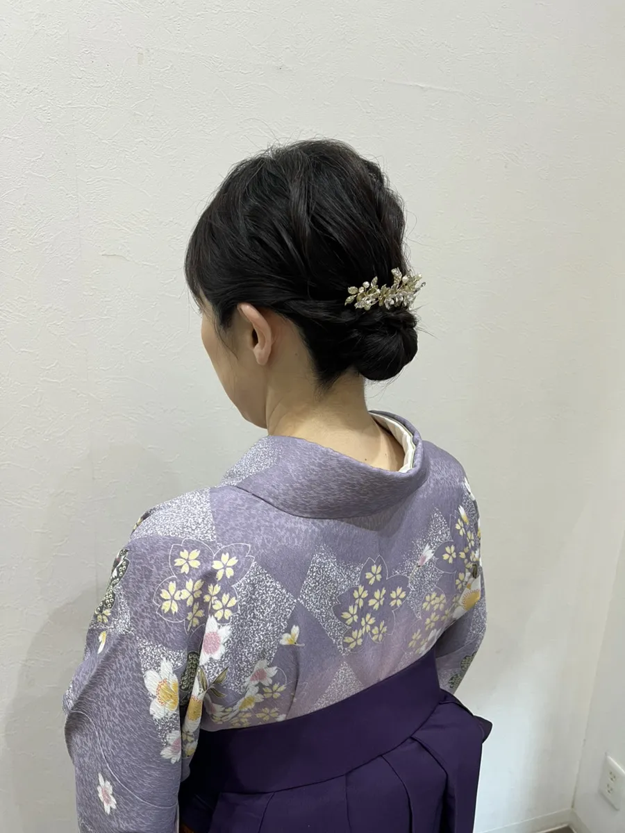 袴の着付けとヘアセットの後ろ姿。藤色の着物に紫の袴
